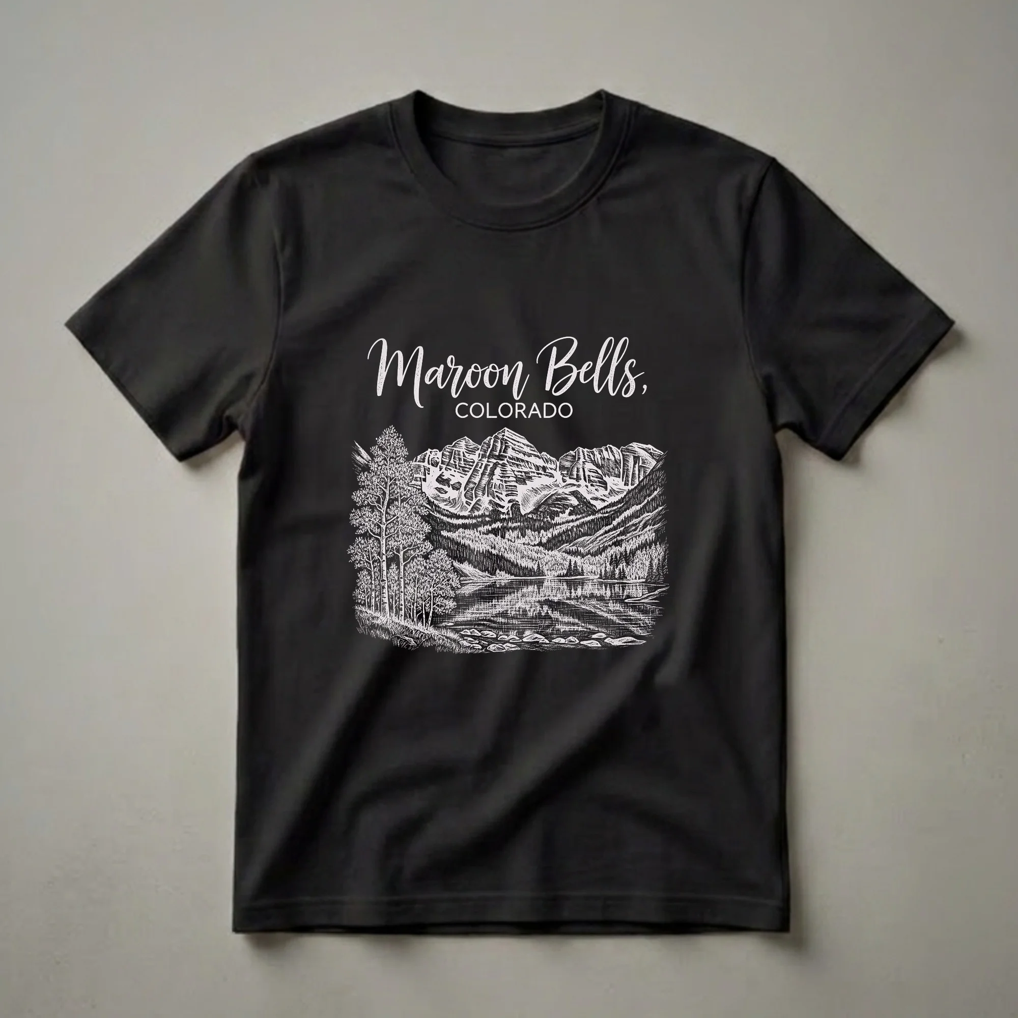 Black t-shirt with a white vintage drawing of the Maroon Bells mountains, a lake reflecting the peaks, and aspen trees in the foreground, with the text 'Maroon Bells, Colorado'.