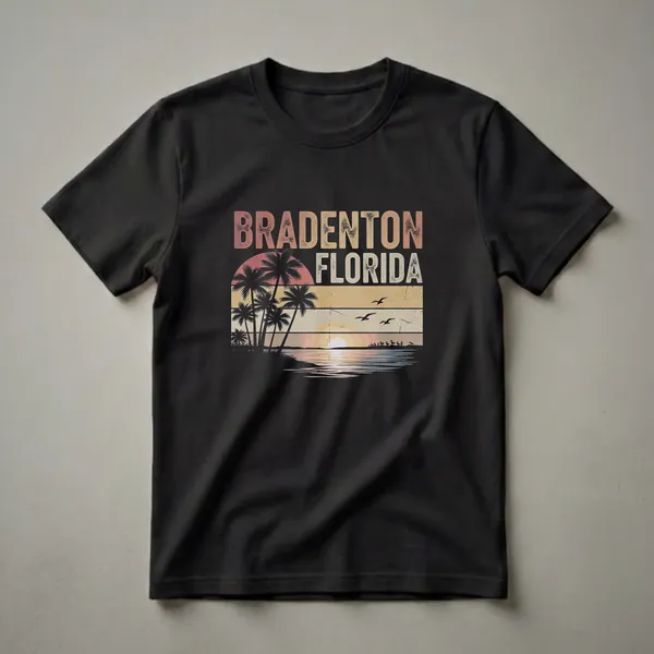 Black t-shirt with a retro graphic design featuring the words "BRADENTON FLORIDA" above a sunset scene with palm trees, birds, and water.