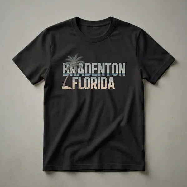 Black t-shirt with "BRADENTON FLORIDA" in large retro font, filled with a beach scene including a palm tree, sand, and ocean waves.