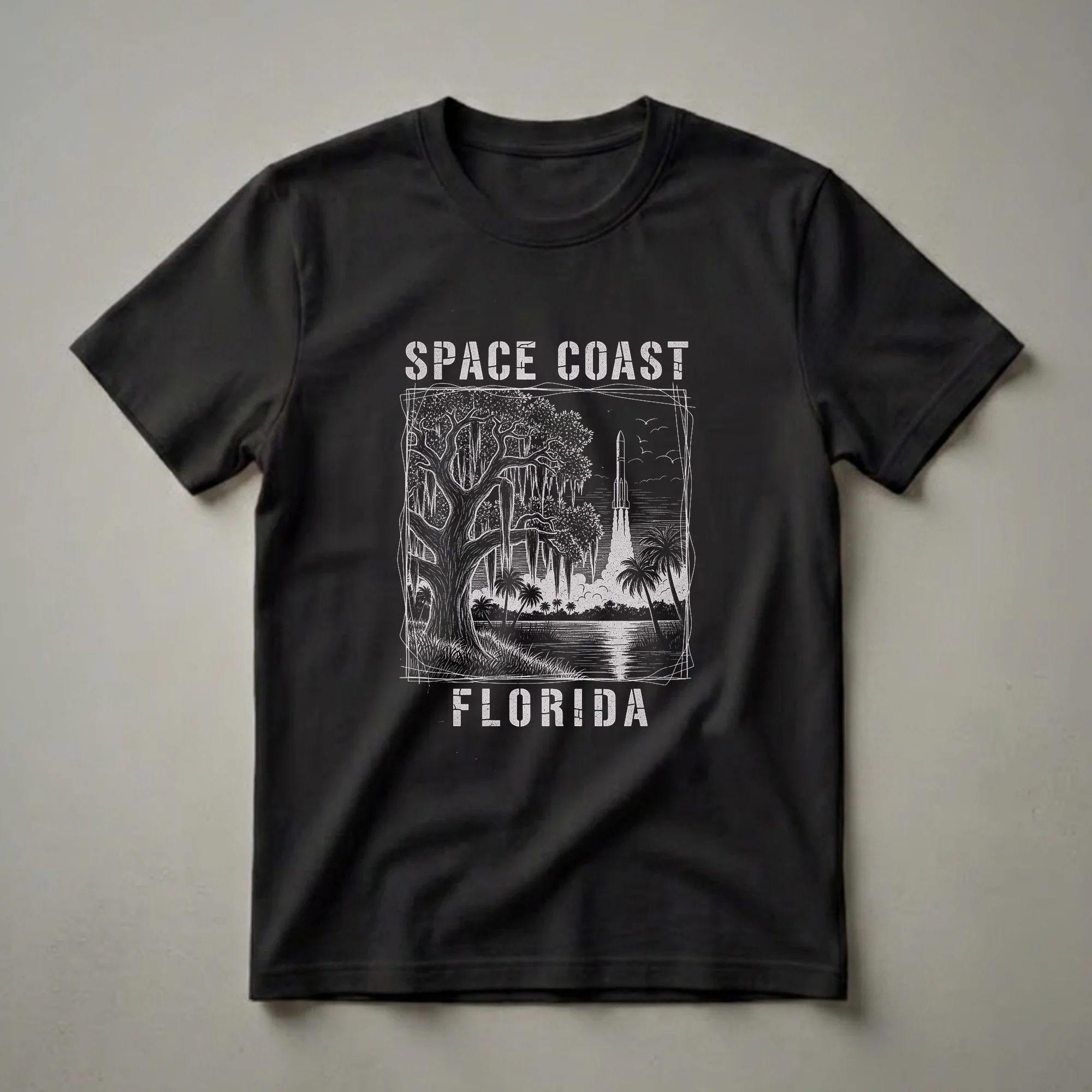 Black t-shirt featuring a vintage white linocut illustration of a rocket launch over a Florida waterway, with a live oak tree and palm trees.