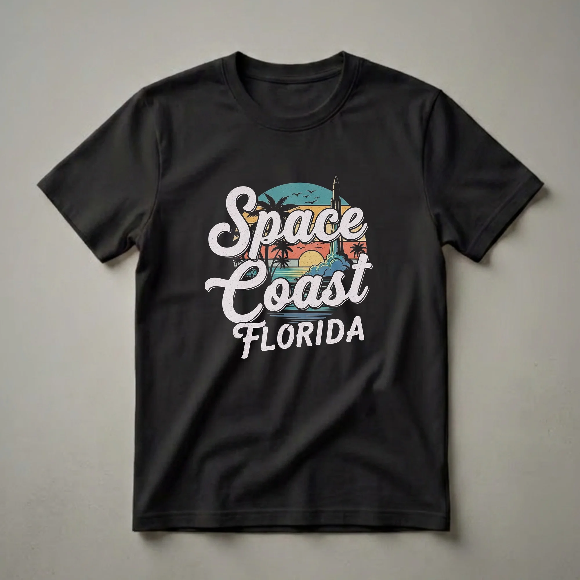 Black t-shirt featuring a retro graphic design of a rocket launching from the Space Coast of Florida at sunset, with palm trees and ocean waves.