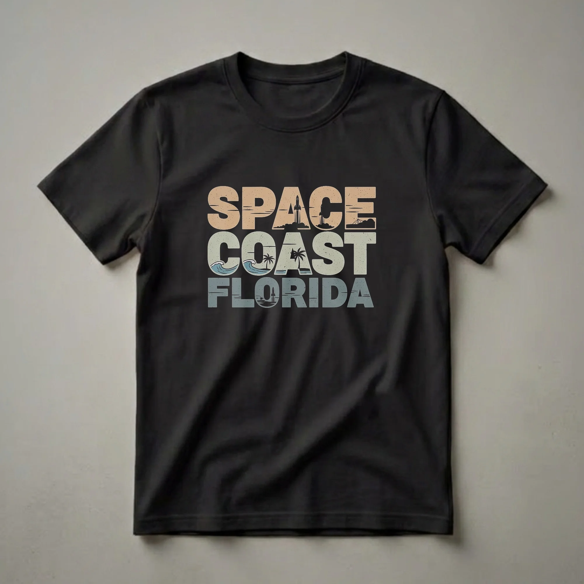 Black t-shirt with retro text reading 'SPACE COAST FLORIDA' featuring graphic elements of rockets, palm trees, and ocean waves.