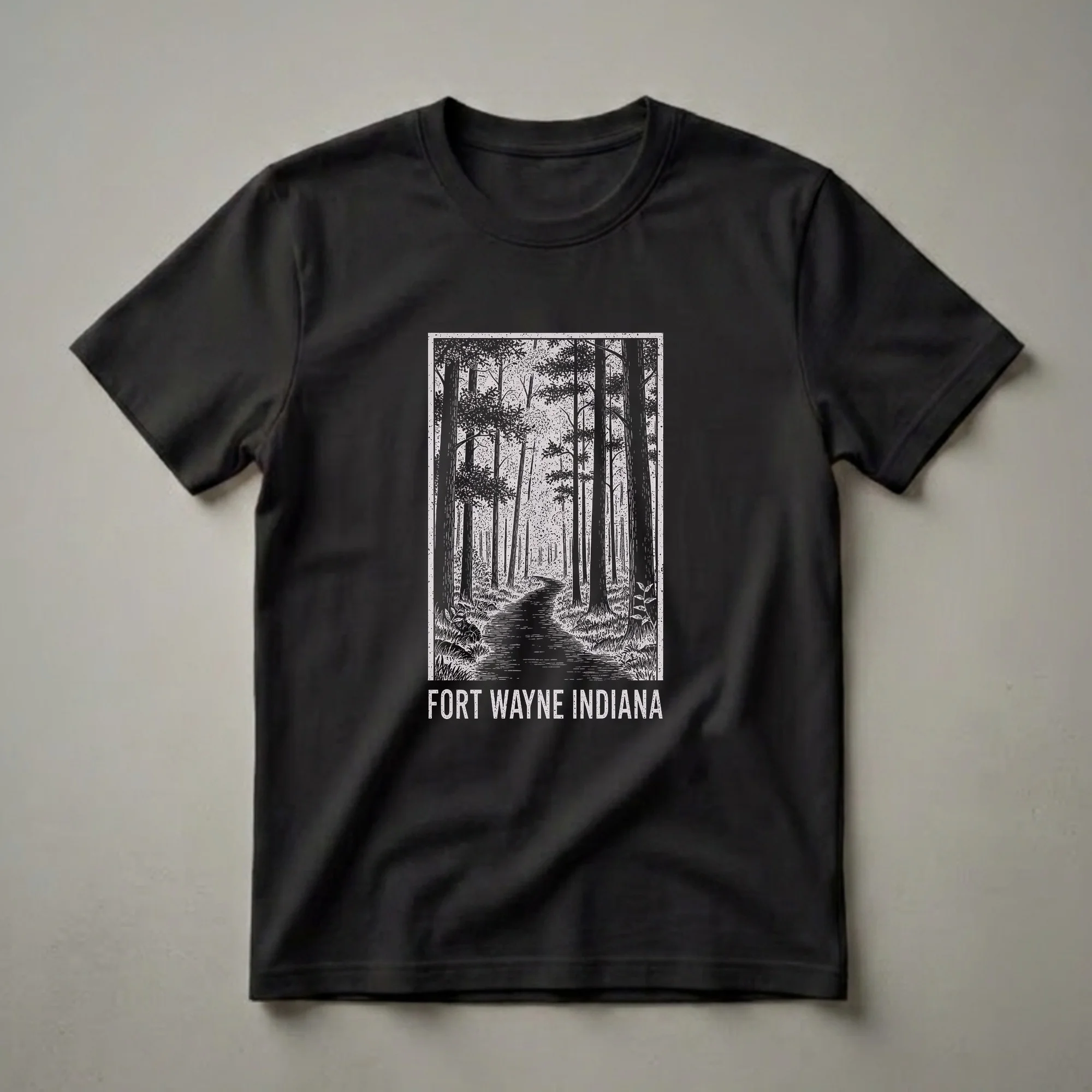 Black graphic t-shirt featuring a vintage woodcut illustration of a forest path with tall trees and the text 'FORT WAYNE INDIANA' below.