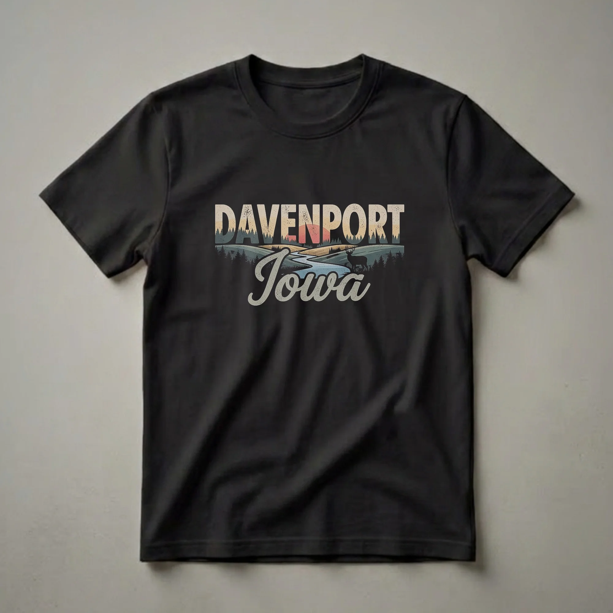 Black t-shirt with a retro graphic design featuring the words Davenport Iowa, a winding river, rolling hills, a deer silhouette, and a sunset.