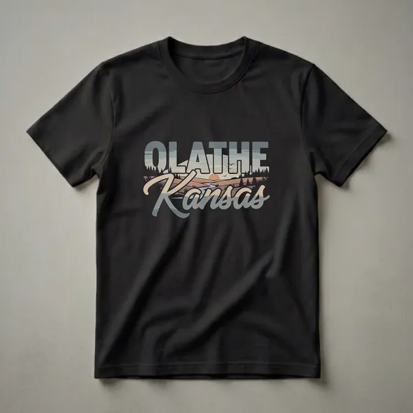 Black t-shirt featuring the words Olathe Kansas in a retro font, with a landscape scene of a river, trees, and sunset filling the letters.