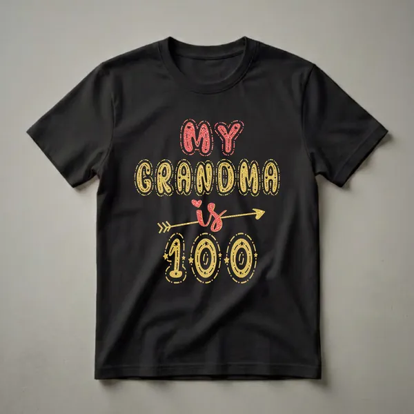 Black t-shirt featuring the text 'MY GRANDMA is 100' in decorative red and gold glittery fonts, with hearts and an arrow graphic.
