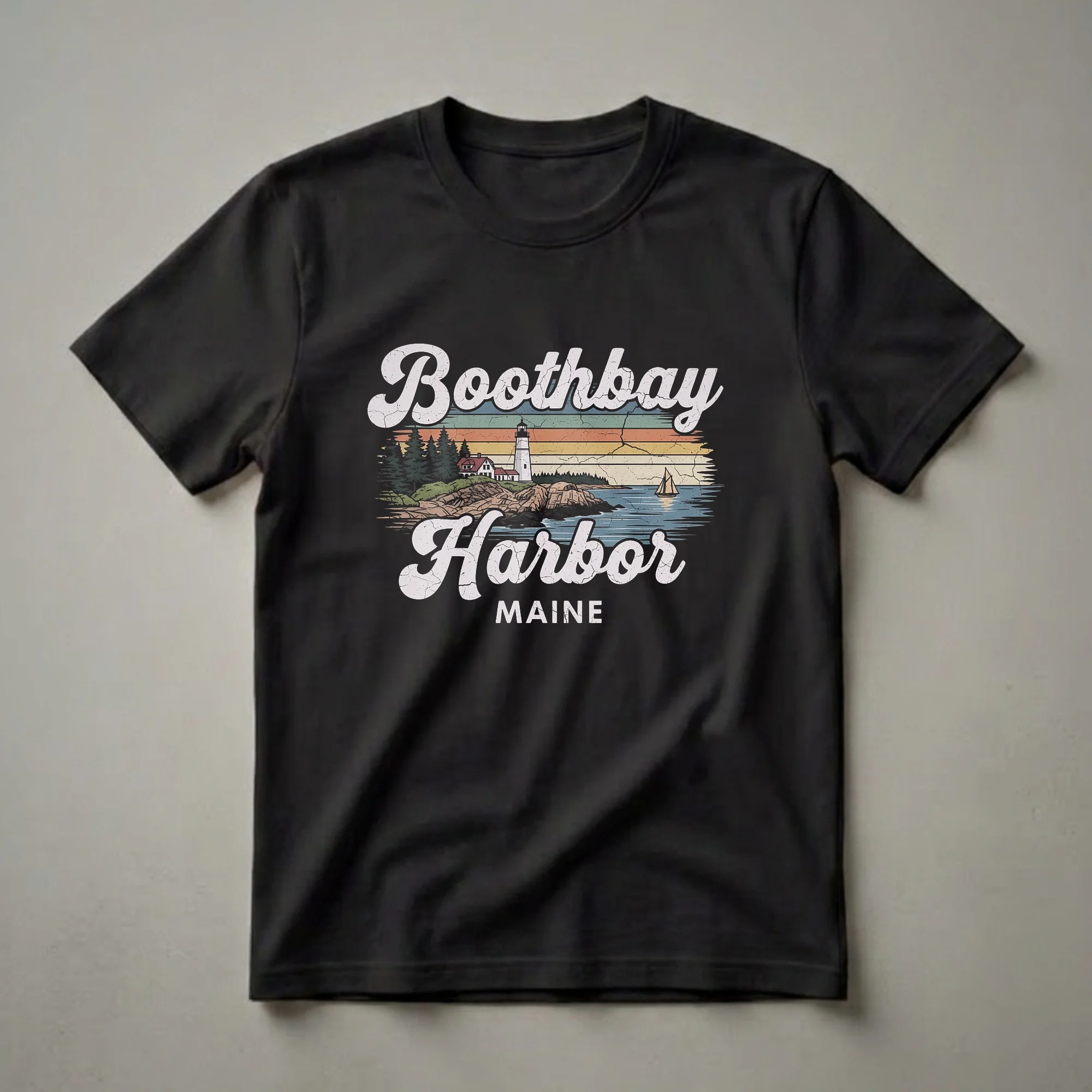 Black graphic t-shirt featuring a retro design of Boothbay Harbor, Maine, with a lighthouse, coastal buildings, pine trees, a sailboat, and distressed horizontal stripes.