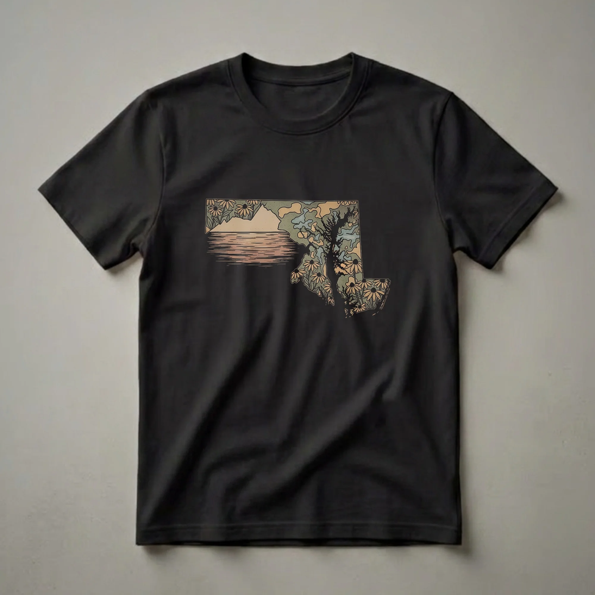 A retro graphic t-shirt design featuring the outline of Maryland filled with a landscape of water, mountains, a tree, and black-eyed Susan flowers in muted earth tones.